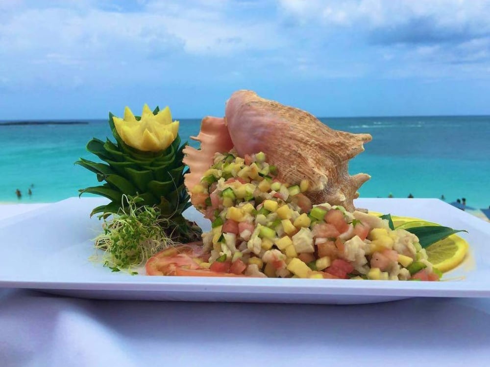 Conch salad on a white plate ocean-side.