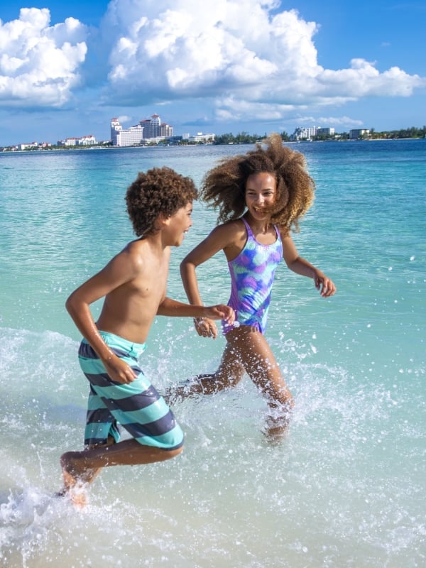A family running on the beach in Nassau Paradise Island, The Bahamas