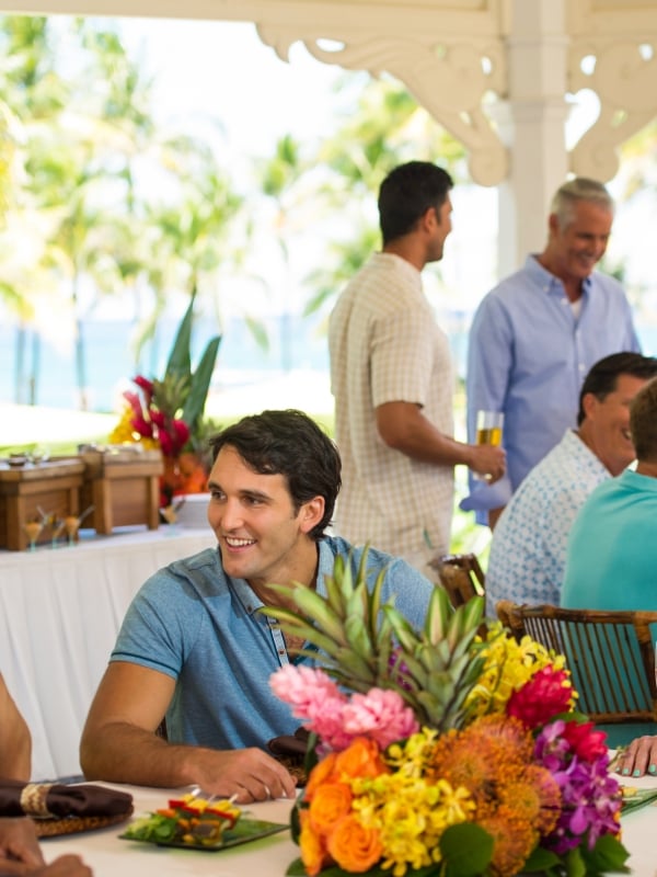 A group of friends enjoys a Bahamian-themed party at a tropically decorated table.