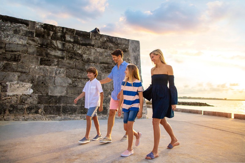A family walks past a historic fort in Nassau, Bahamas. 