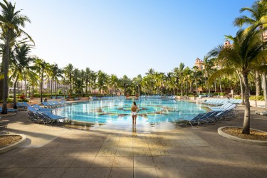 A woman standing in front of a pool in a bathing suit