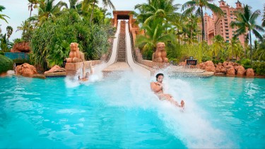 Two people splashing into a pool after sliding down the Challenger Slide at Aquaventure.