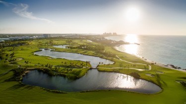 An aerial view of a sunrise coming up over Ocean Club Golf Course.