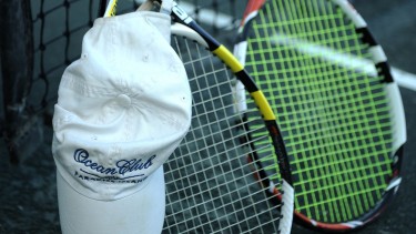 Two tennis rackets and a ball cap.