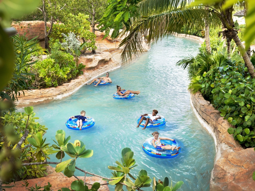 A family tubing down a lazy river at Atlantis, Paradise Island
