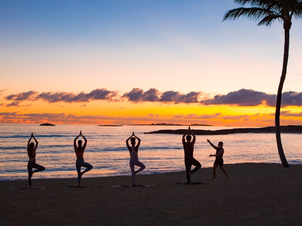 A group doing yoga on the beach in Nassau
