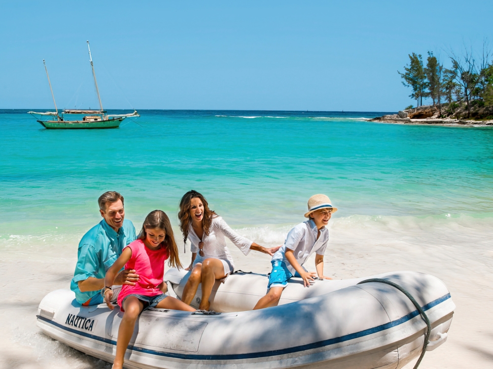 A family climbing out of a dinghy in The Bahamas