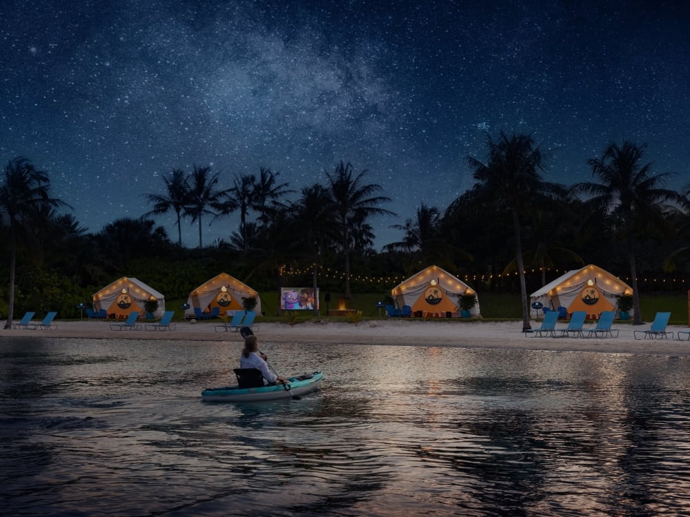 A person kayaking towards a group of tents in Nassau Paradise Island