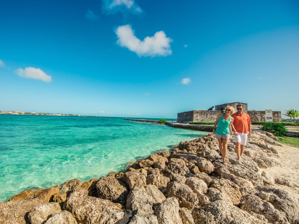 A couple walking along Fort Montagu Beach in Nassau 