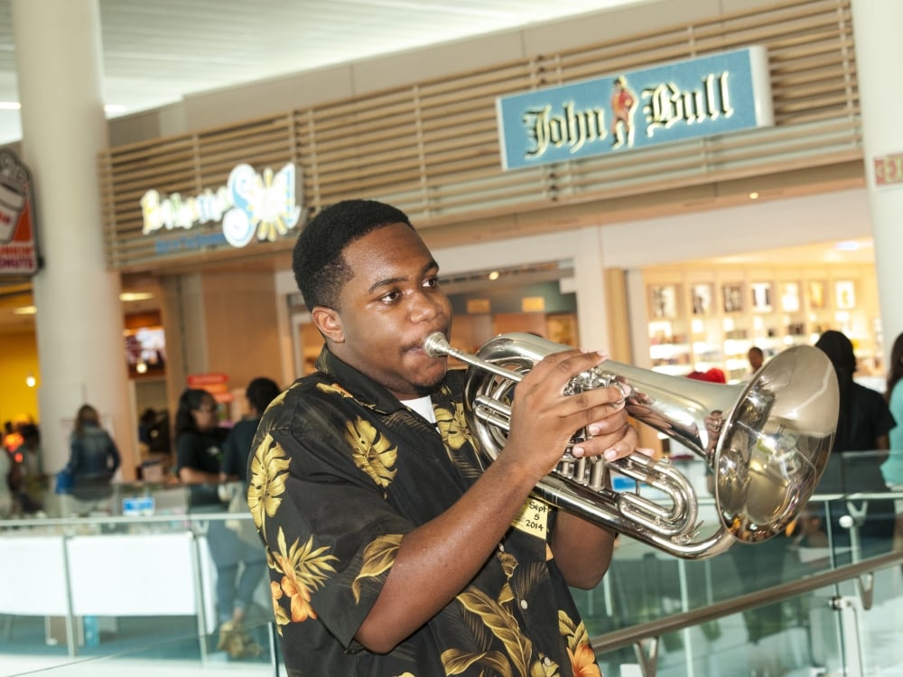 A man playing the trumpet at Nassau airport