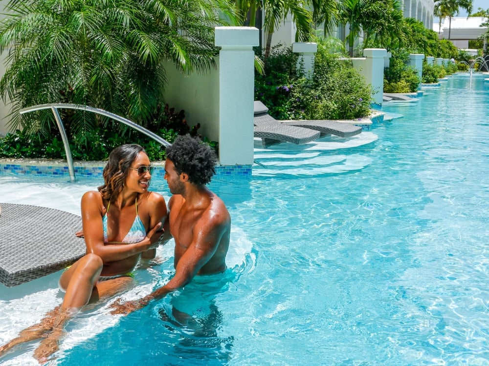 A couple enjoying a Love Nest suite at Sandals Royal Bahamian