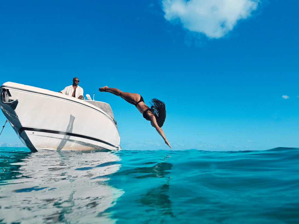 woman diving off a boat into water