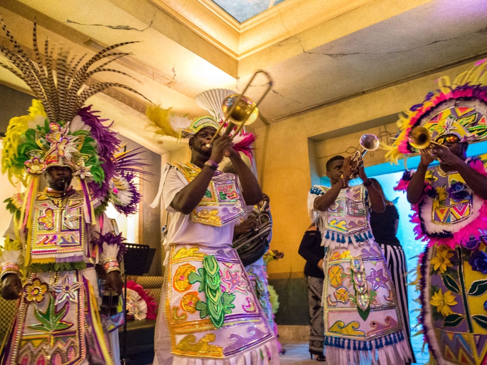 A group of traditional Junkanoo musicians play instruments in costume.