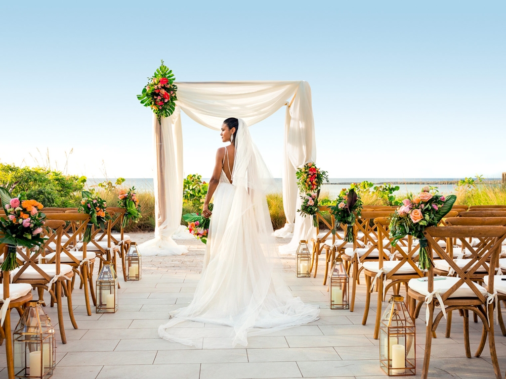 A bride walks down the aisle at her outdoor Bahamian wedding.