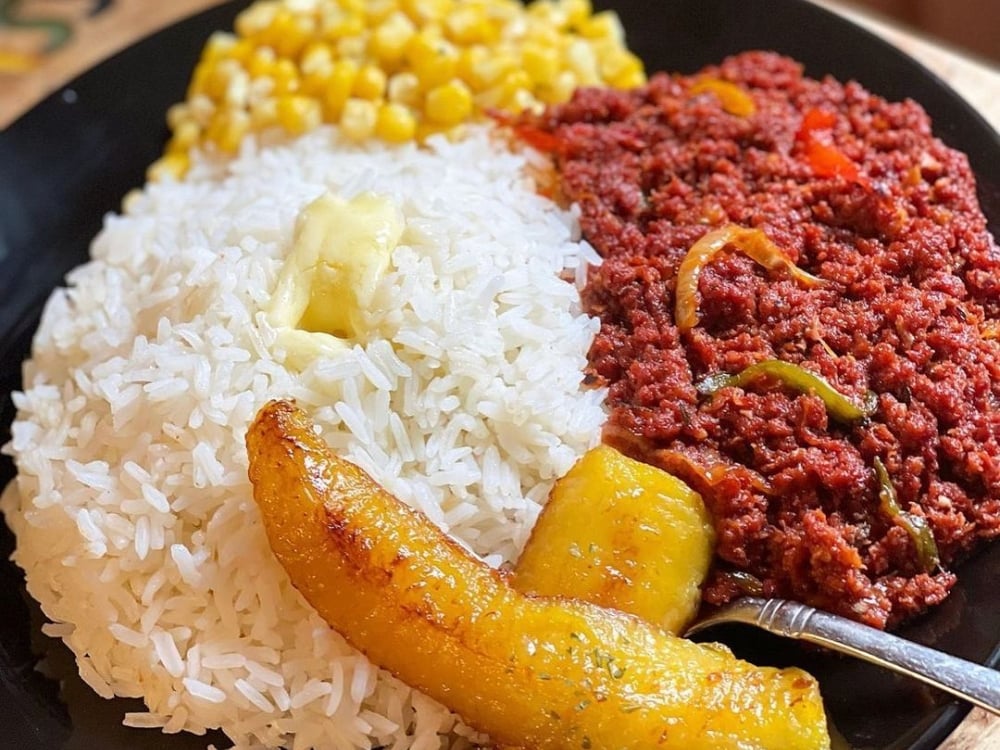 A plate of corned beef, white rice, and canned corn.
