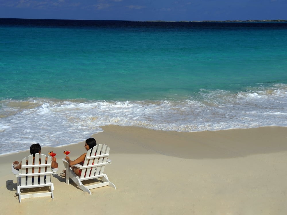 A couple sitting on Cabbage Beach in Nassau Paradise Island, The Bahamas