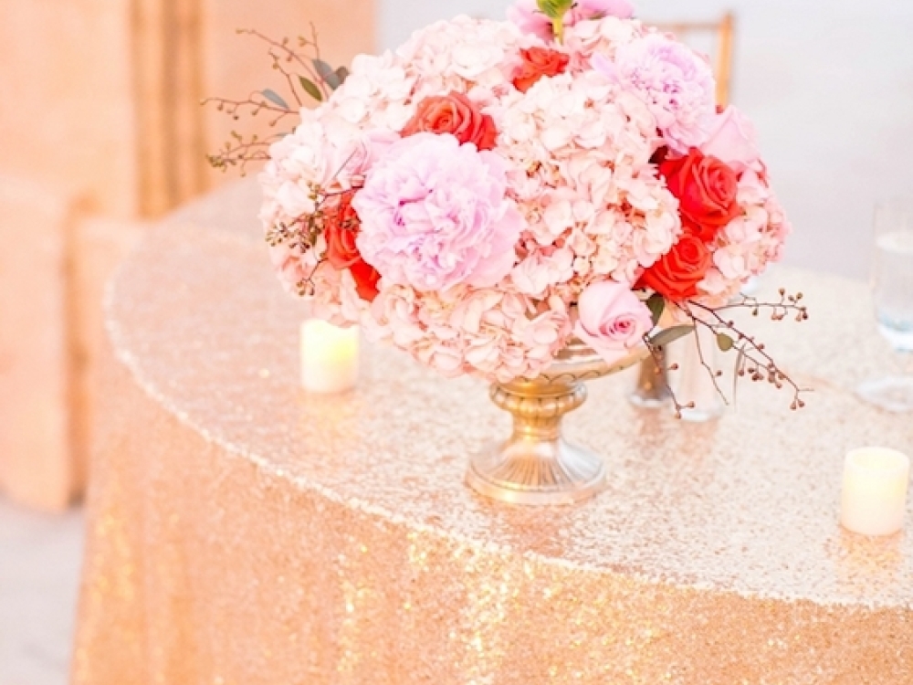 A pink floral bouquet sits on a beautiful gold tablecloth at an Atlantis wedding. 