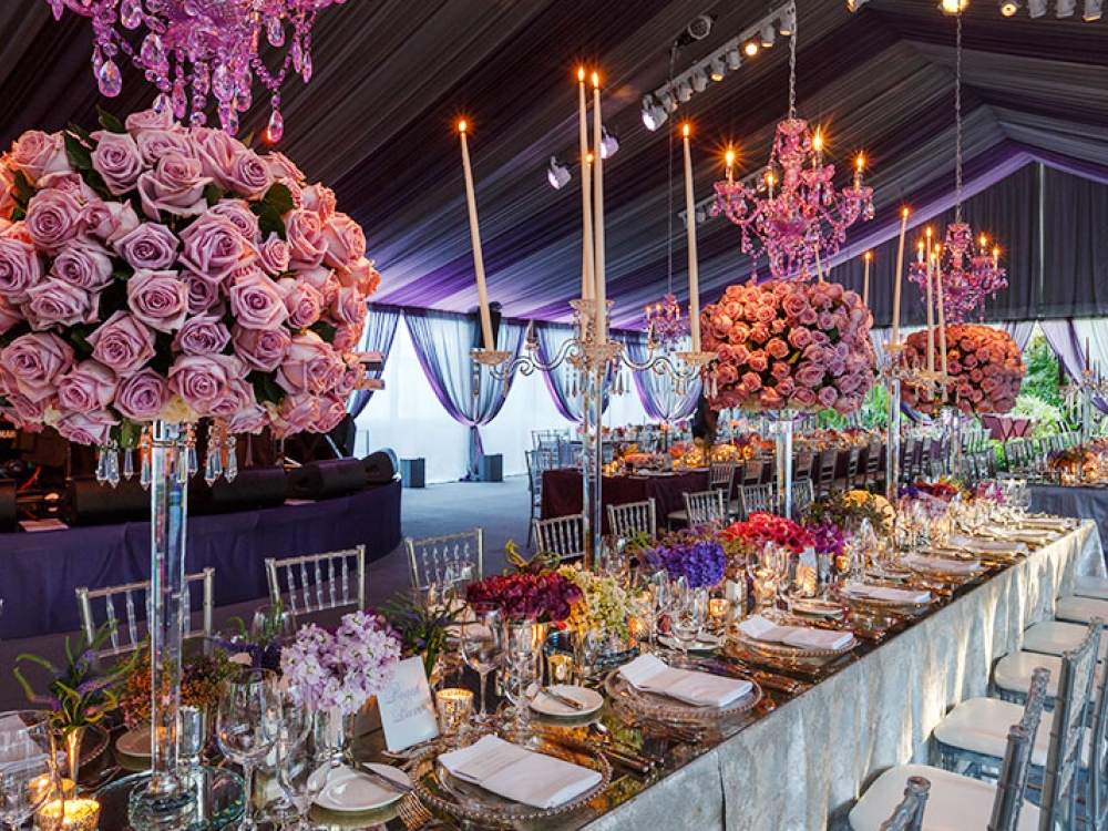 Dramatic table decor, chandeliers and rose bouquets decorate a wedding reception in Nassau Paradise Island, Bahamas