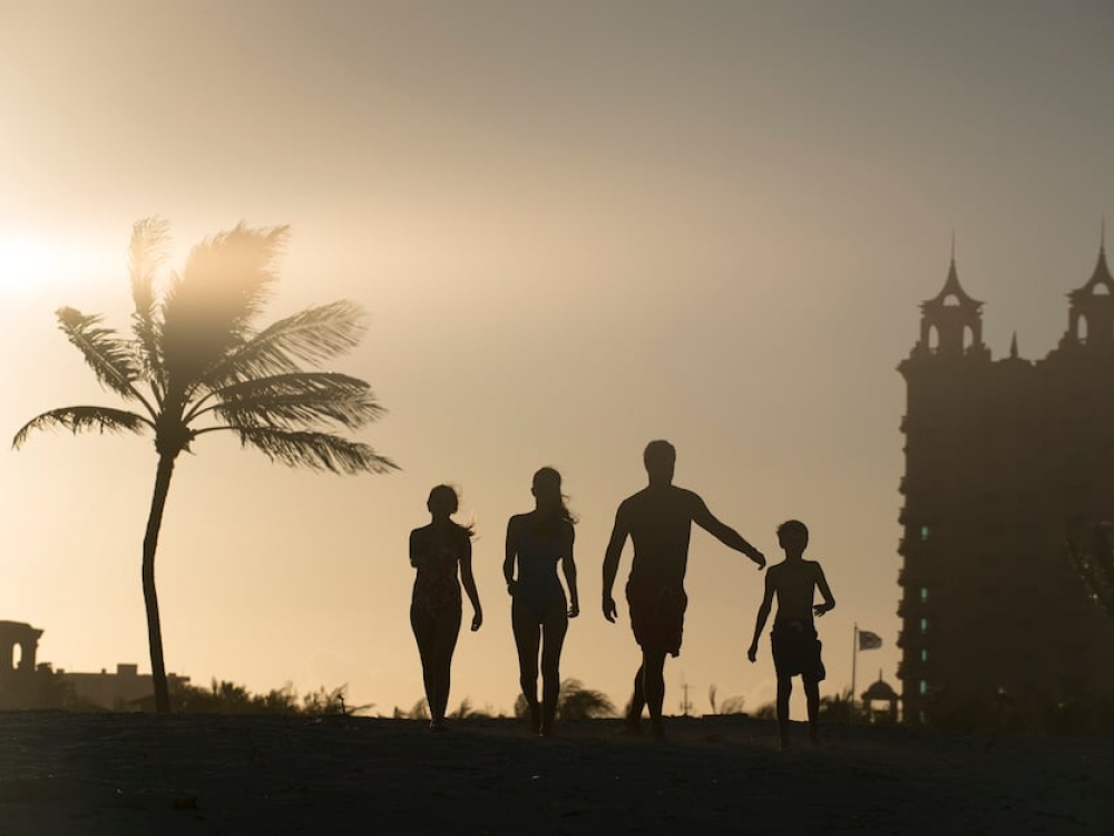 Silhouette of a family of four walking towards the Beach Towers at Atlantis, Paradise Island