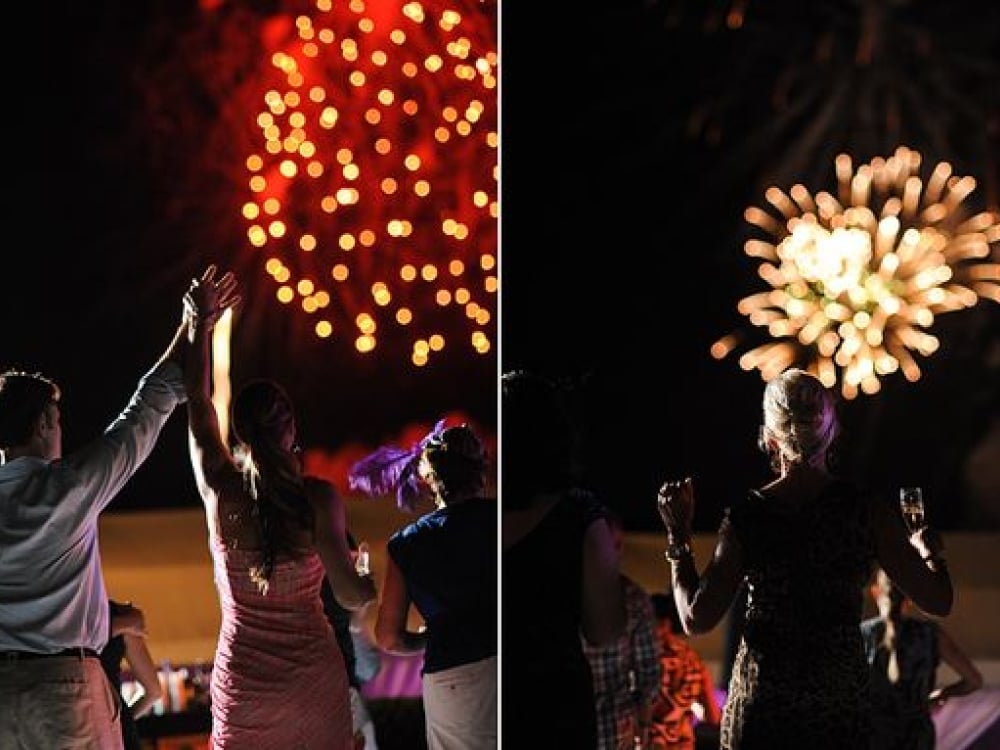 Wedding guests enjoy fireworks at a destination wedding at One&Only Ocean Club in the Bahamas.