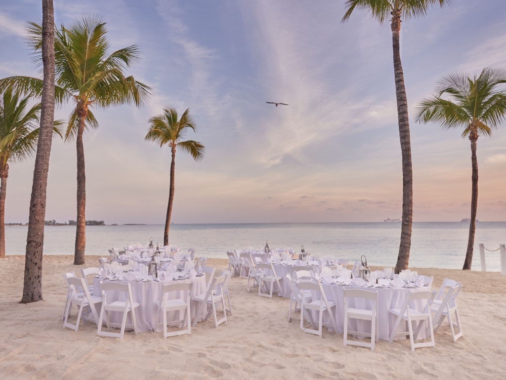 Tables for a wedding reception set up on a Bahamas beach.