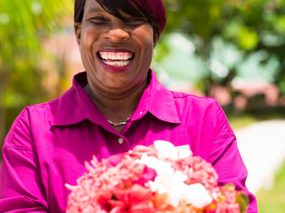 Woman in a pink shirt holding a bouquet of flowers
