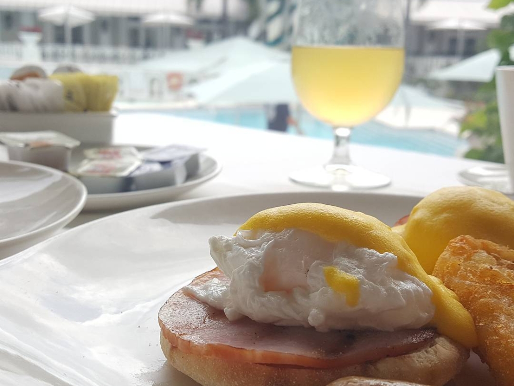 Eggs Benedict and sausage breakfast served at Sandals Royal Bahamian.