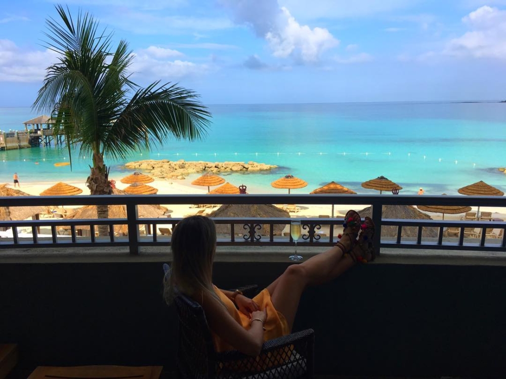 A woman puts her feet up on a terrace overlooking the water in Paradise Island, Bahamas.