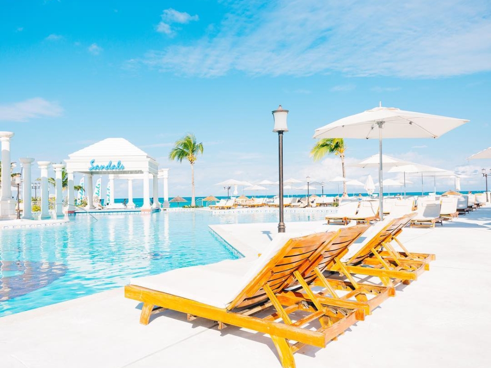 Pool loungers next to one of the seven pools at Sandals Royal Bahamian all-inclusive resort.