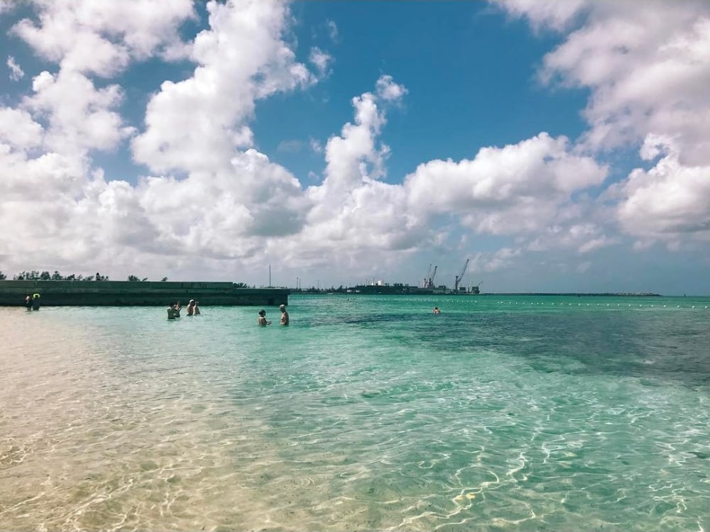 Visitors wade in the clear, turquoise water at Junkanoo Beach.