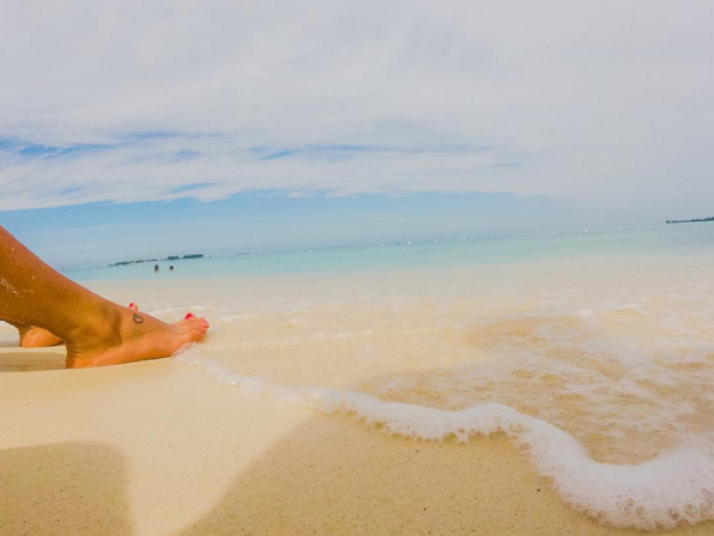 A visitor's bare feet enjoy the warm waves on Cable beach.