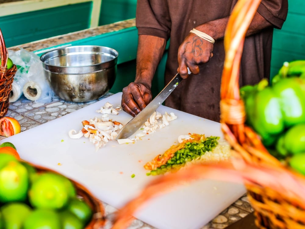 A chef chops fresh conch meat for conch salad in The Bahamas. 