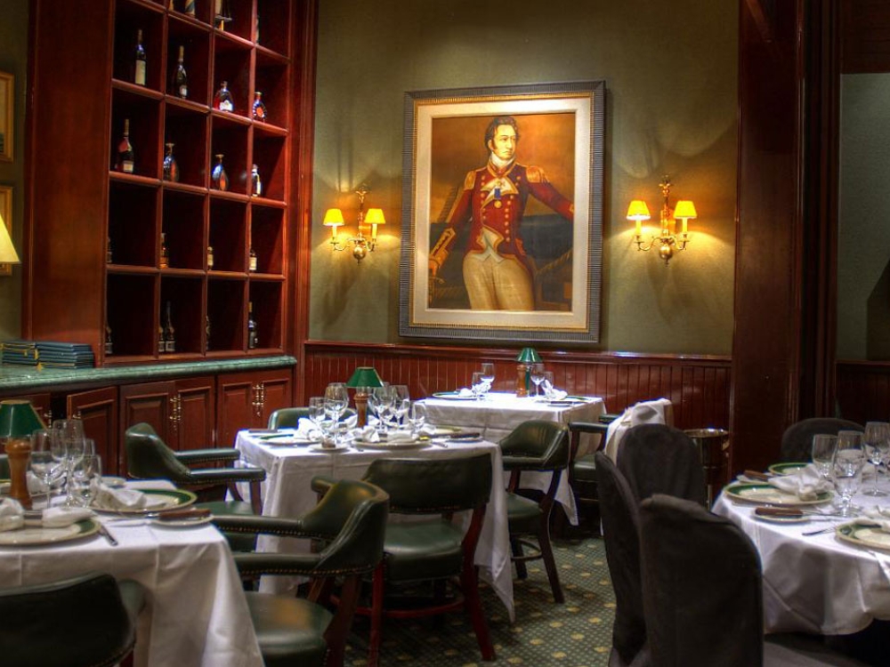 Dimly lit dining room with portrait in the background