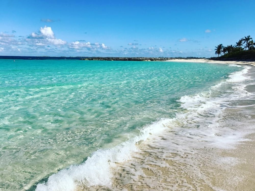 A wave of turquoise water washes ashore at Cabbage Beach.