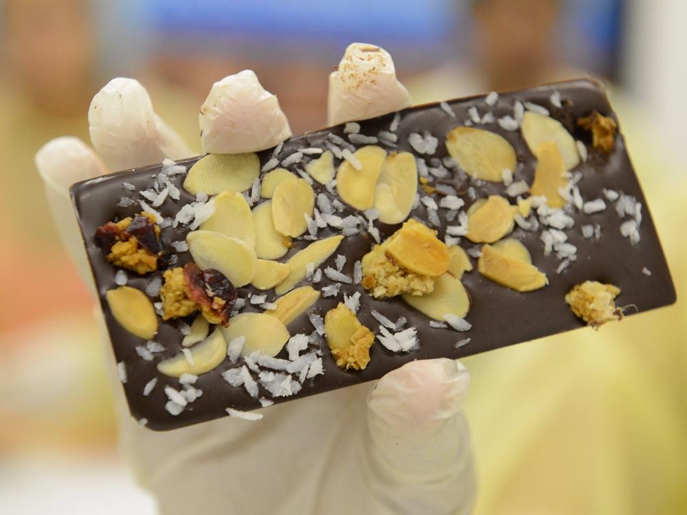 A handmade chocolate bar with coconut and almonds.