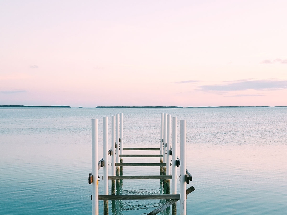 A dock going out over water during a sunset