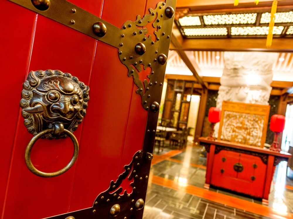 The ornate red door and Chinese decor of Shuang Ba Restaurant in The Bahamas