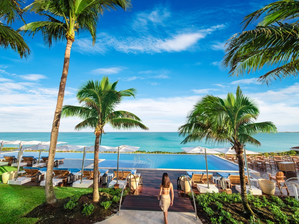 Lady walking towards a pool at a resort