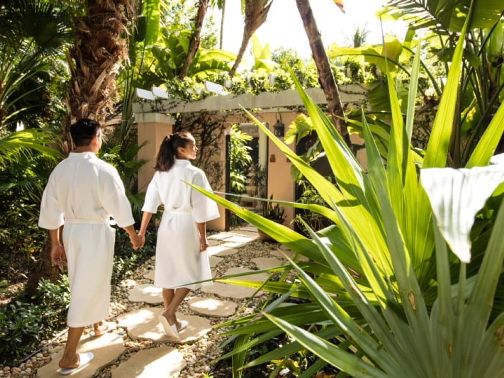 A couple walking in robes outside a spa in Nassau Paradise Island
