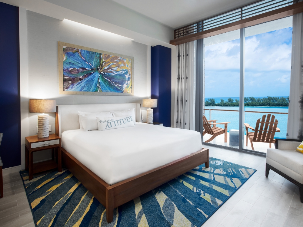 King bed in a hotel room with an ocean view.