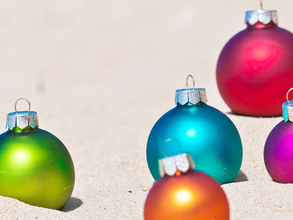 Holiday ornaments on a white sand beach