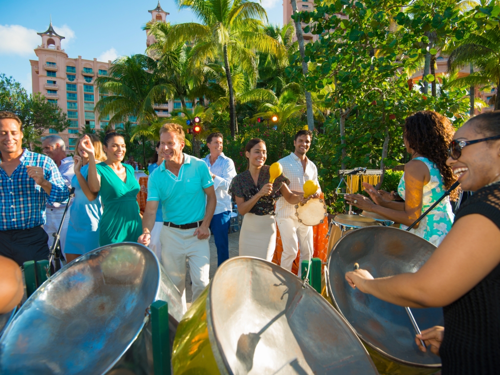 A group dances in the sun to a steel drum band in The Bahamas.