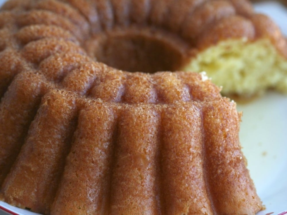 Rum bundt cake on a white plate with a slice out of it.