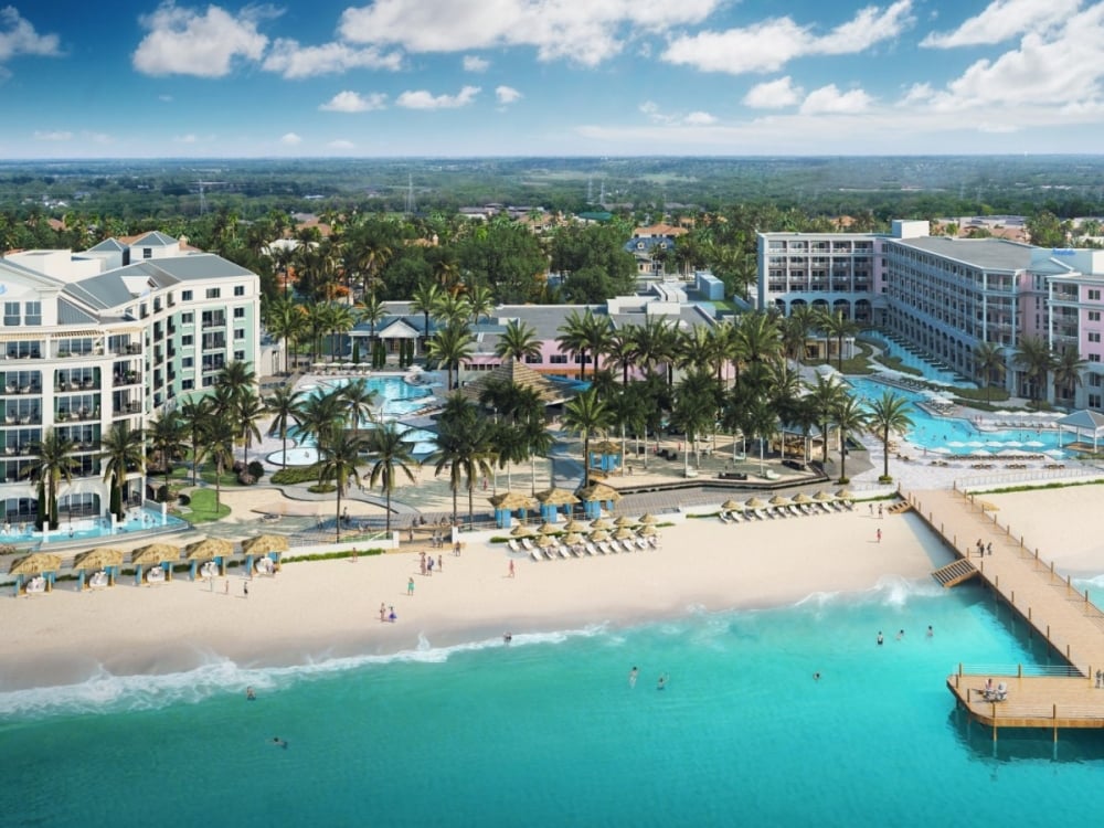 Ariel shot of a resort with three buildings and a dock in the water