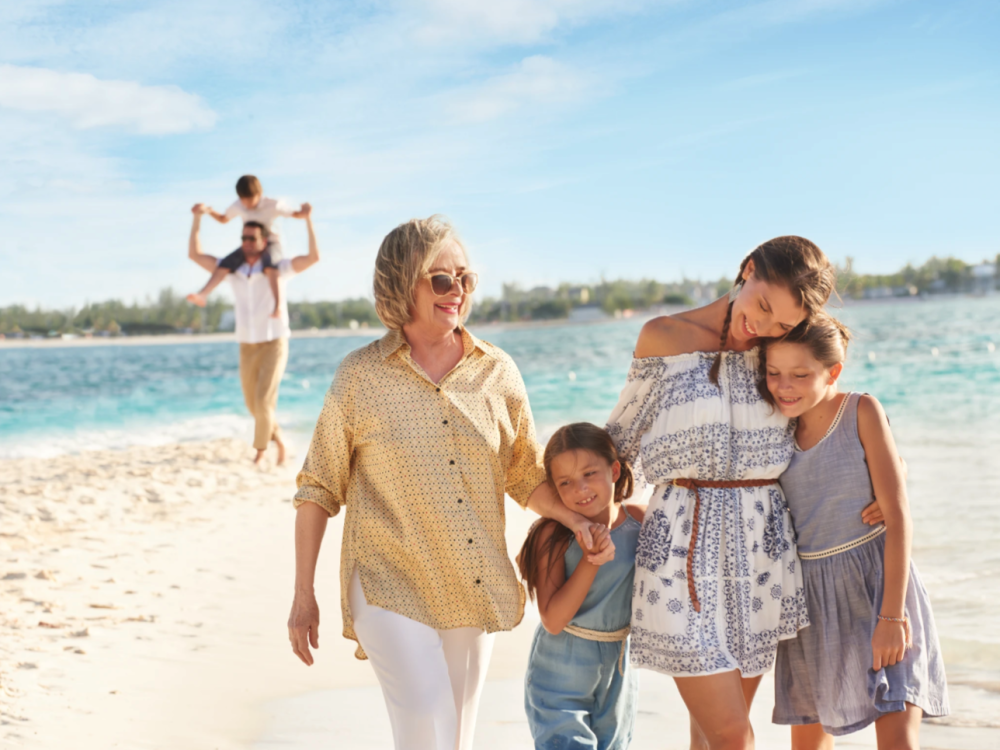 A multigenerational family walks along the beach in The Bahamas. 