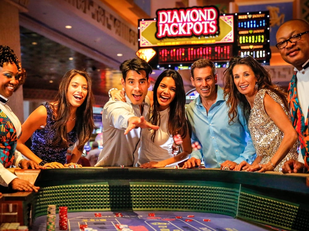 A group of men and women enjoying a game of craps in a casino.