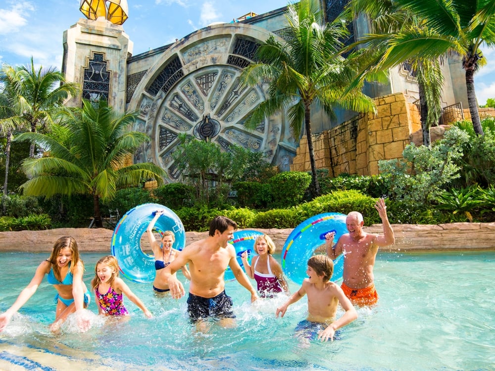 A family grab their inflatable inner tubes and prepare for a water rapids adventure.