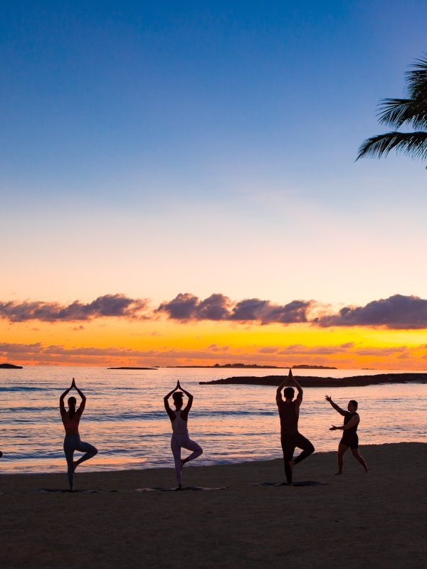 A group doing yoga on the beach in Nassau