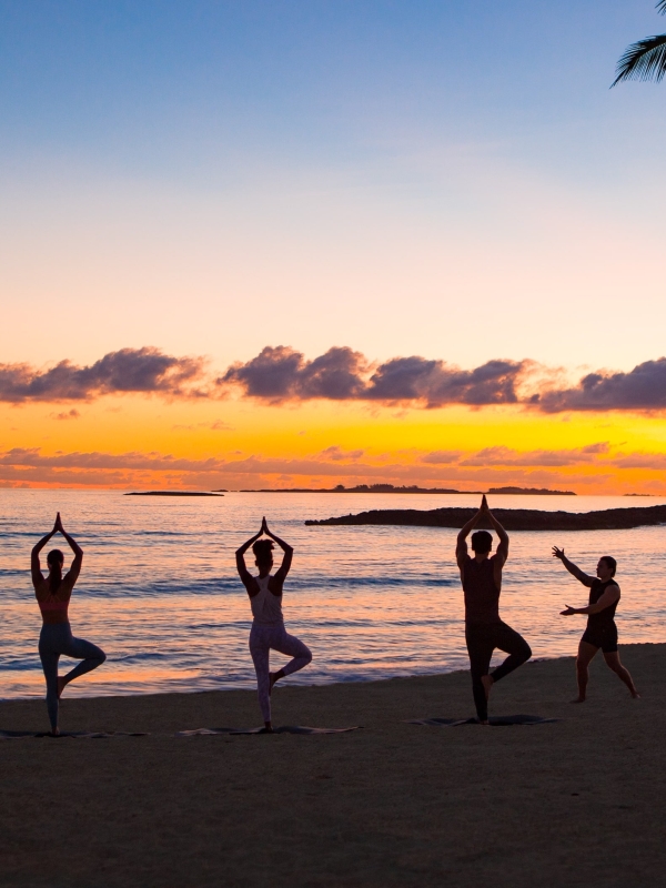 A group doing yoga on the beach in Nassau
