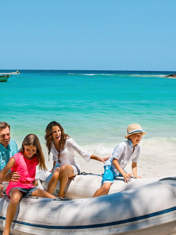 A family climbing out of a dinghy in The Bahamas